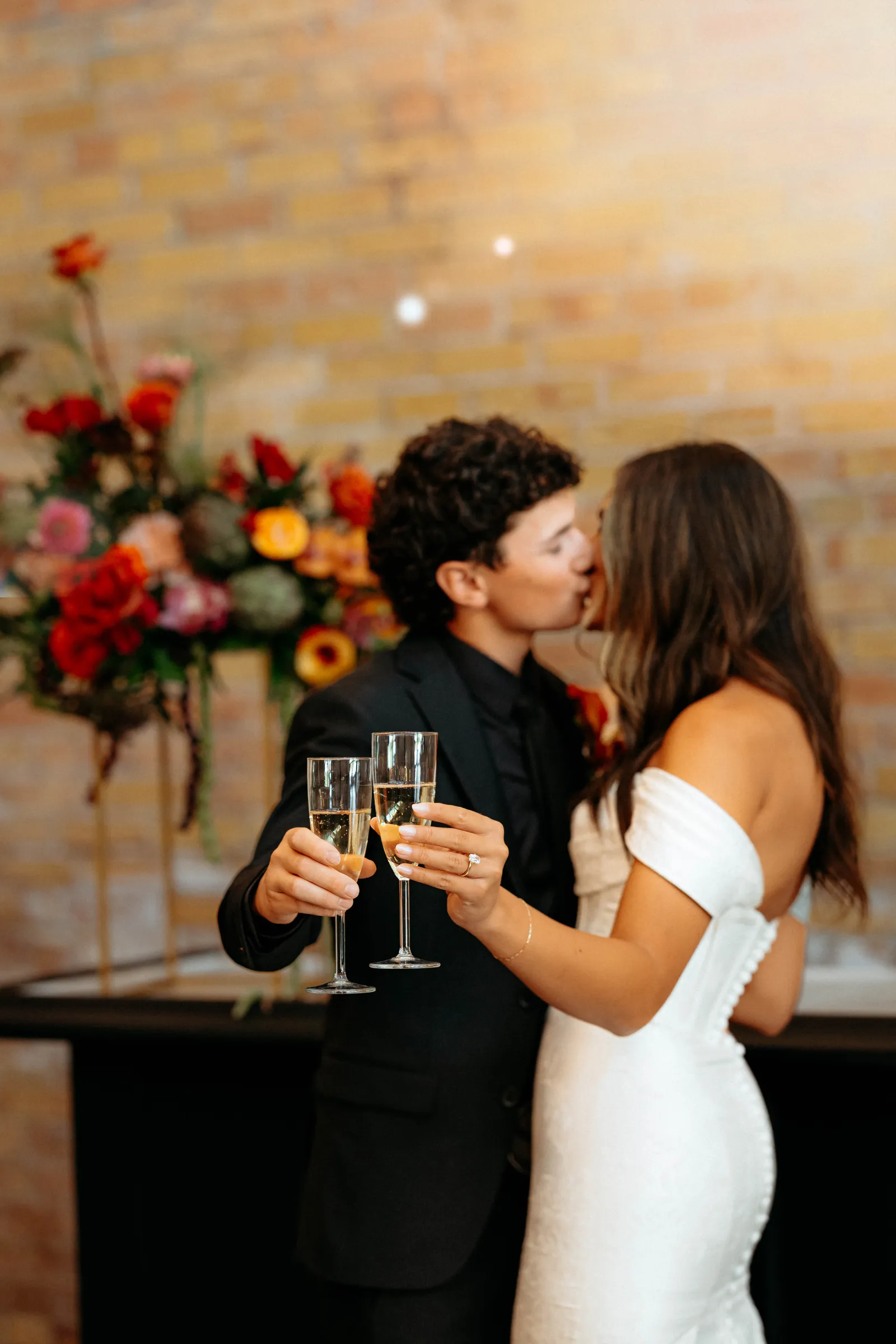 Newlyweds toasting champagne and kissing in the Copper Nickel hall
